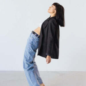 A woman is standing on a white wall