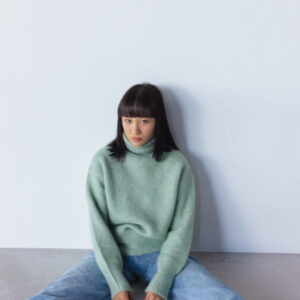 A woman sitting on a floor with a blue and white sheet